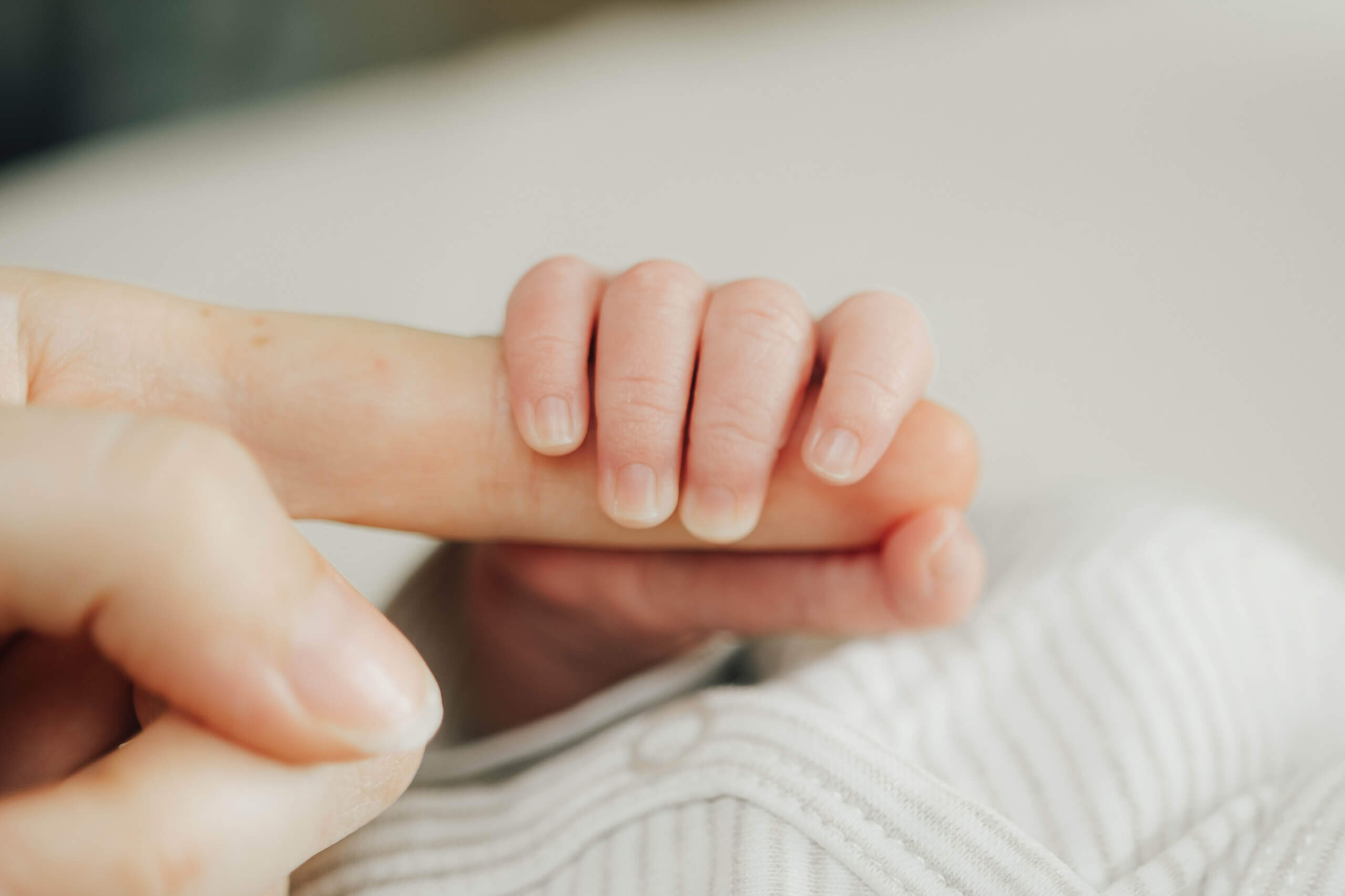 Neugeborenen-Hand hält Finger, Newbornfotos Salzburg
