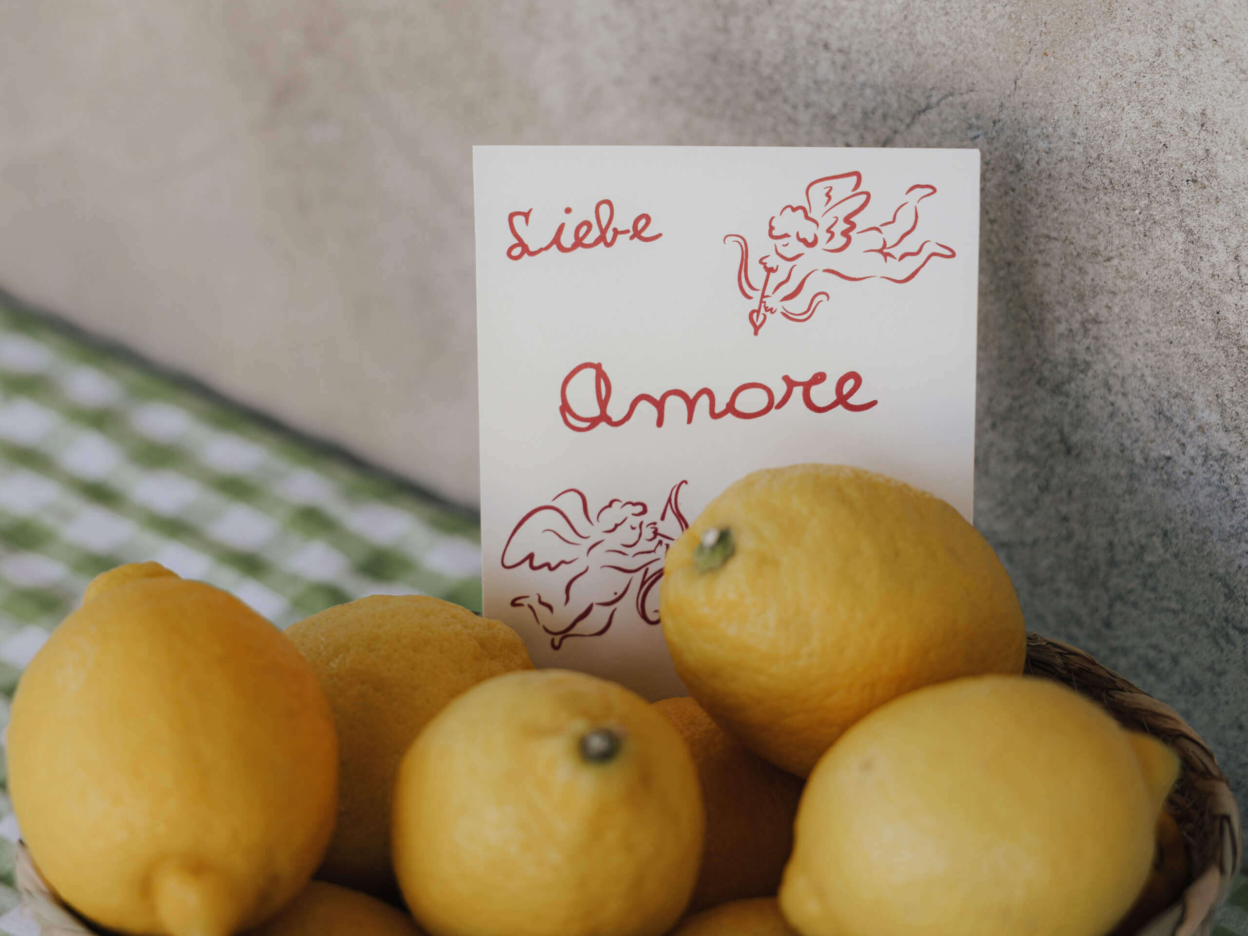 Korb mit Zitronen und Karte mit "Liebe Amore"